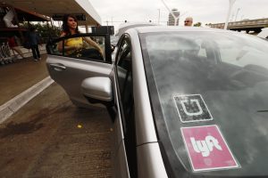 Both Uber and Lyft logos on a car